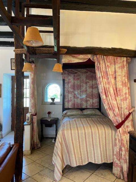 Un chambre à coucher confortable avec un lit à baldaquin et des poutres apparentes au plafond. Font Valley, gîtes à la ferme.