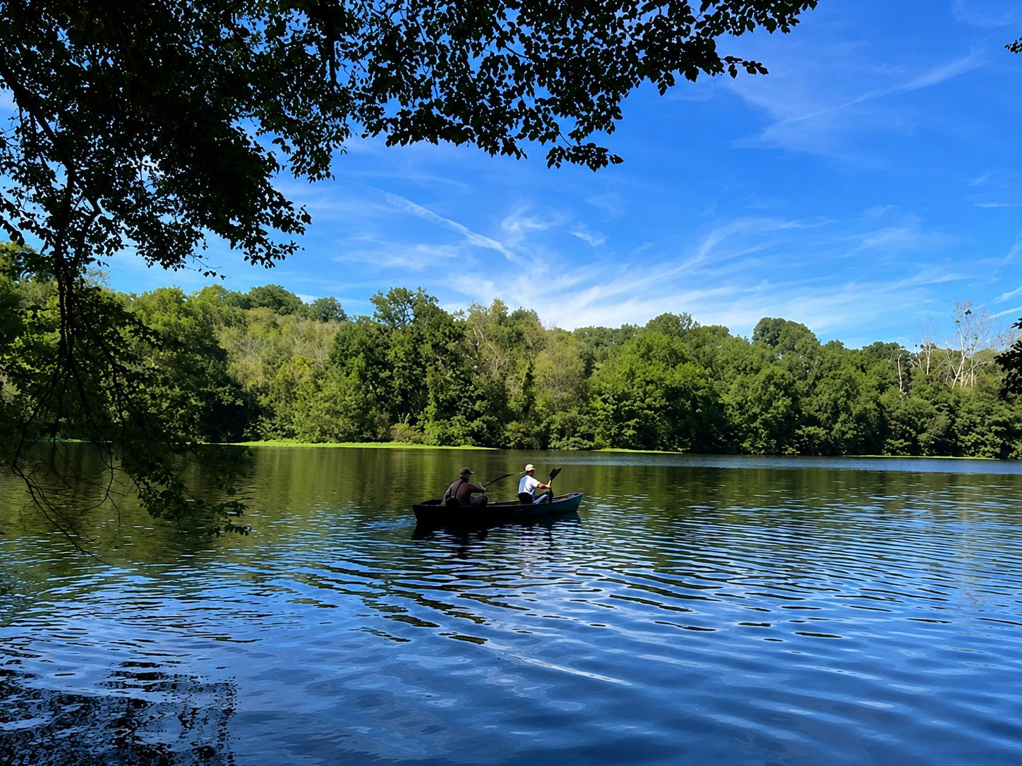 Une rivière calme qui coule au milieu de la verdure. On aperçoit une barque au milieu de l'eau avec deux occupants. Font valley, gîtes à la ferme. Une rivière calme qui coule au milieu de la verdure. On aperçoit une barque au milieu de l'eau avec deux occupants. Font valley, gîtes à la ferme.